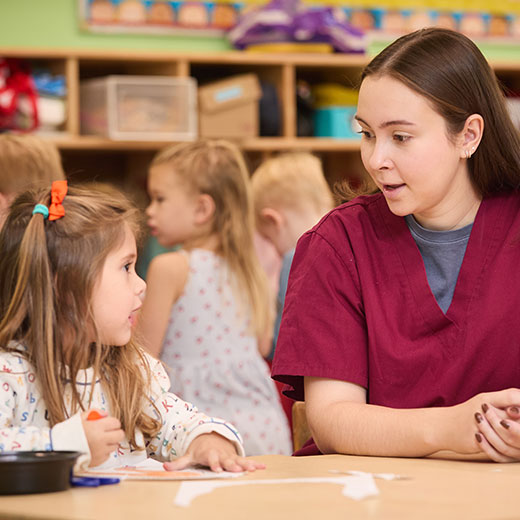 A student talking to a little girl.