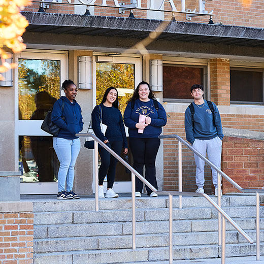 Students walking out of a building. Links to Gifts by Estate Note