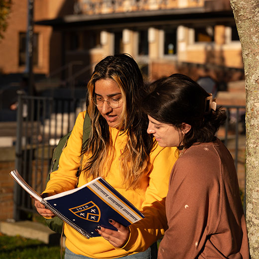 Two students looking at a notebook. Links to Donor-Advised Funds